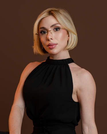 Thayná Moura em um retrato de estúdio, usando blusa preta sem mangas.